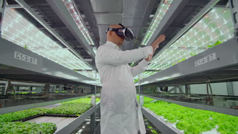 Plantación-Hidropónica-Vertical-De-Un-Hombre-Con-Bata-Blanca-Utilizando-Tecnología-De-Realidad-Virtual-Que-Simula-El-Funcionamiento-De-La-Interfaz.