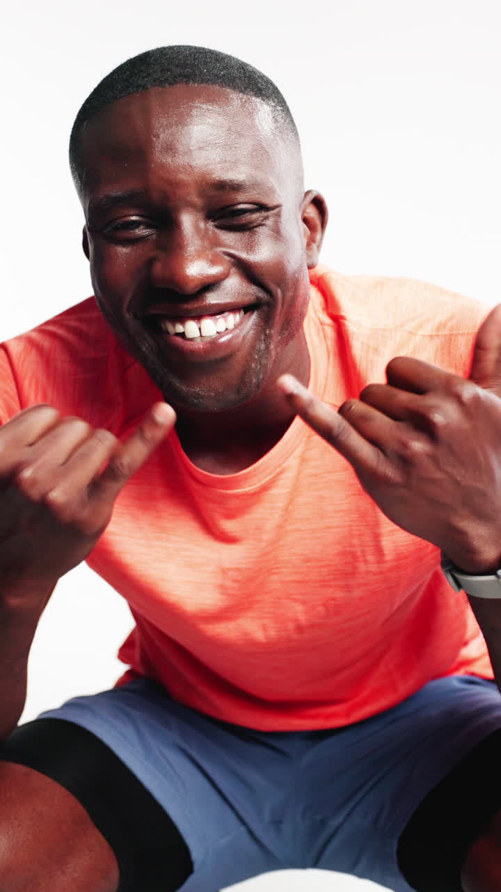 Uomo afroamericano sorridente che fa il gesto dello Shaka in studio