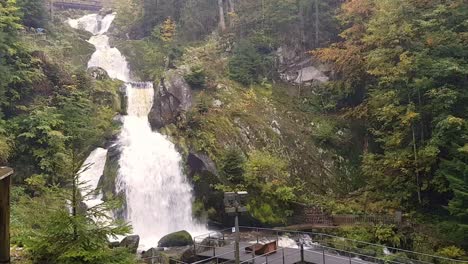 Static-wide-shot-of-beautiful-massive-Triberg-waterfall-in-woodland-during-fall-season,-Schwarzwald-black-forest,-Germany