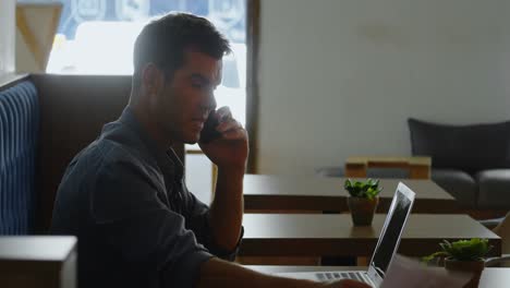 Man-talking-on-mobile-phone-at-cafe-4k