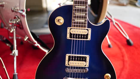 a vintage blue electric guitar six string on a concert stage in a rock and roll garage band setting