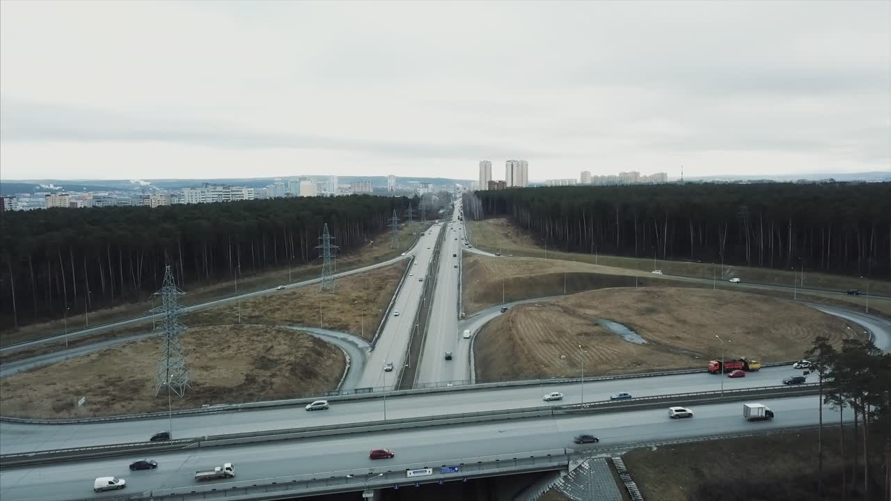 пересечение шоссе над городским пейзажем и лесом
