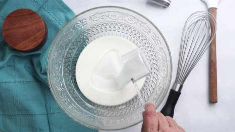 making a dessert called red raspberry tea cake made with fresh berries and vanilla buttercream frosting. great for tea parties. mixing in the granulated sugar to the bowl and mixing into the batter
