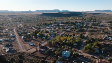 volando sobre la montaña para revelar una pequeña ciudad rural del oeste de texas, fort davis cerca del parque nacional big bend, drone empujado en la hora de oro en 4k