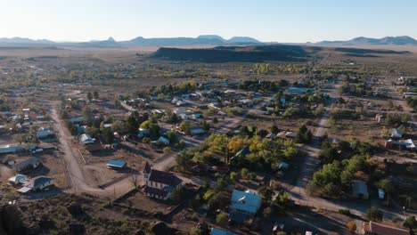 flying over mountain to reveal small rural west texas town, fort davis near big bend national park, drone push in at golden hour in 4k