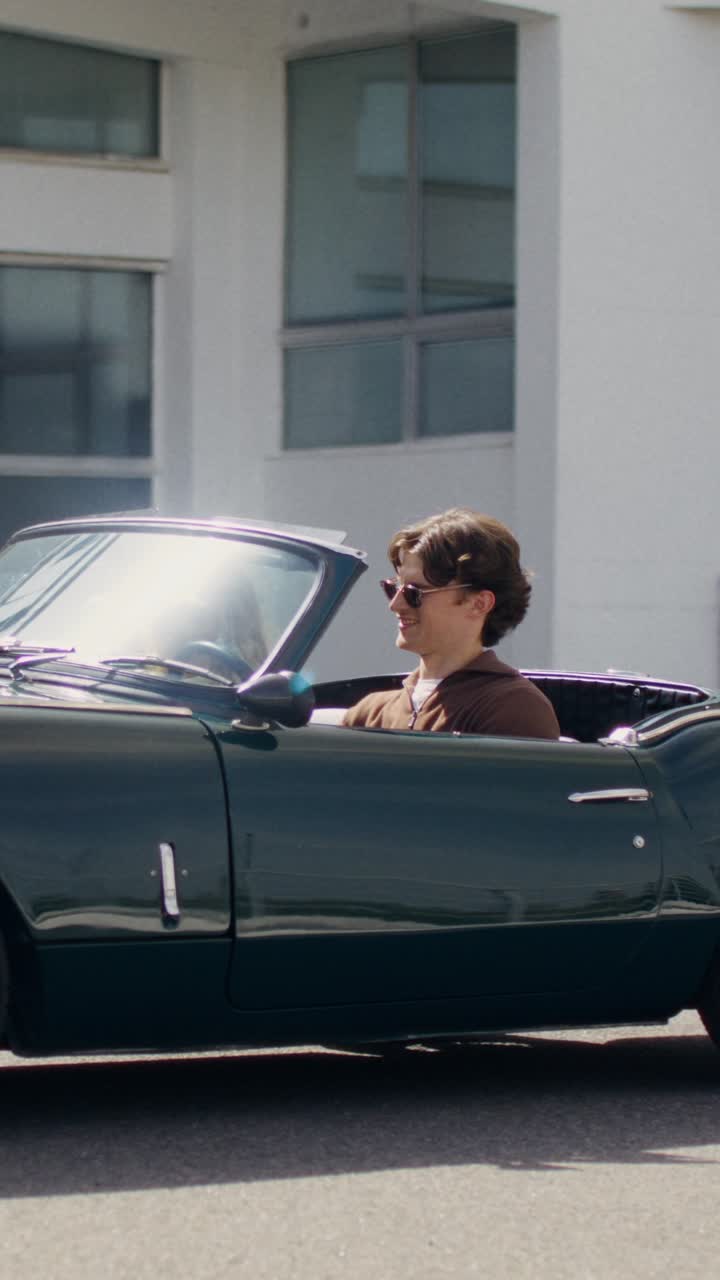 Man driving a vintage convertible car