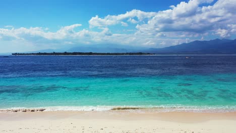 idyllic exotic beach with white sand washed by crystal emerald water of blue turquoise sea on a bright sky with clouds background in bali