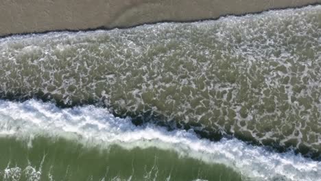 aerial view of waves straight down on sea shore