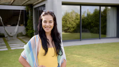 a young biracial woman smiles warmly outdoors in the backyard at home, copy space