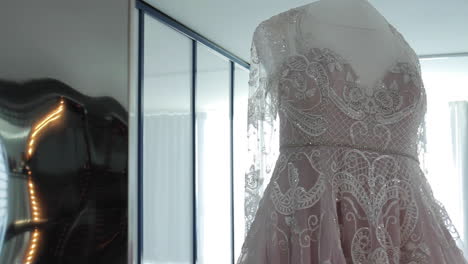 Wedding-Dress-Hanging-near-Bright-Window-at-Wedding-Venue