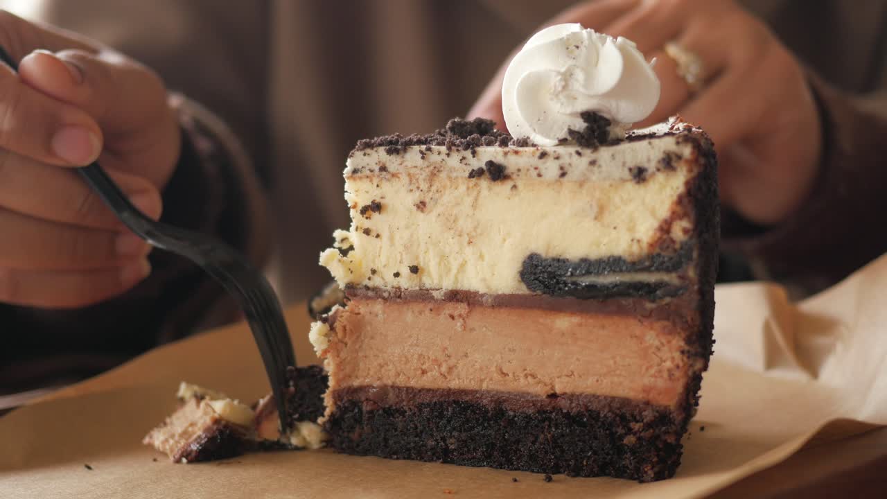 Persona che mangia una deliziosa fetta di cheesecake a strati
