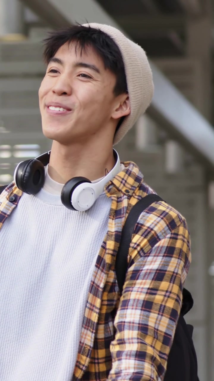 縦型動画：ビーニー帽をかぶった男性が振り返って握手し、友人が駅に現れる。