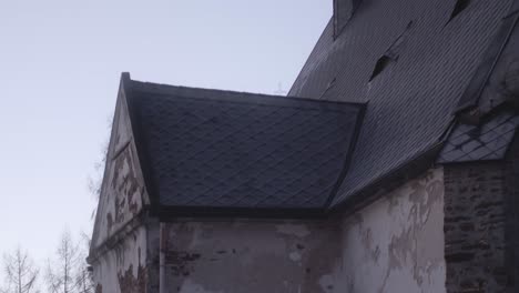 slow camera movement from the church wall to the bell tower on the roof