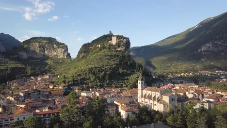 toma aérea de una ciudad histórica en italia, con un edificio en un acantilado - arco, riva del garda, trentino