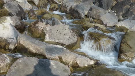 water gently cascades over rocks in the swiss alps near walensee, creating a soothing and peaceful scene that highlights the natural beauty and tranquility of the alpine landscape.