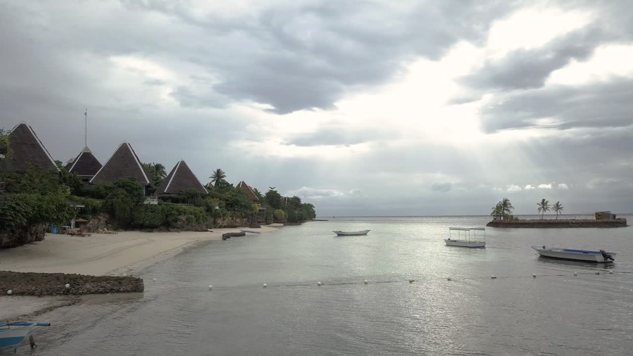 해가 뜨면 바다에 떠 있는 보트가 있는 해변 휴양지 오두막