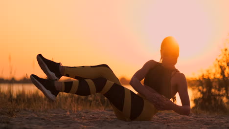 fit healthy woman stretching on yoga mat on beach seasidedoing exercise abdominal crunchestraining and lifestyle. sit ups training on dock beach in sunset