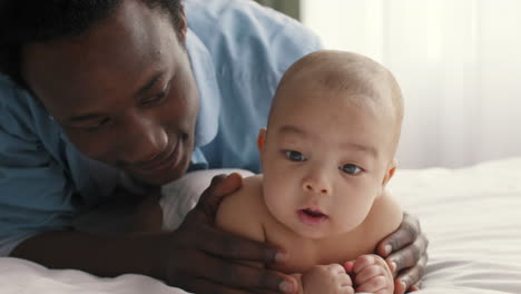 african american father bonding with his baby during tummy time