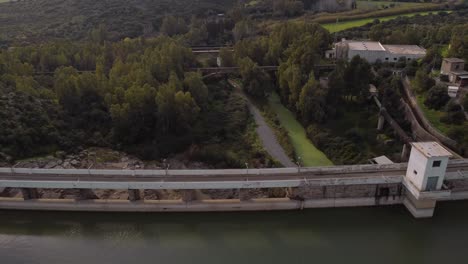 Establisher-aerial-of-Tratalias-dam-reveals-industrial-and-natural-panorama,-day