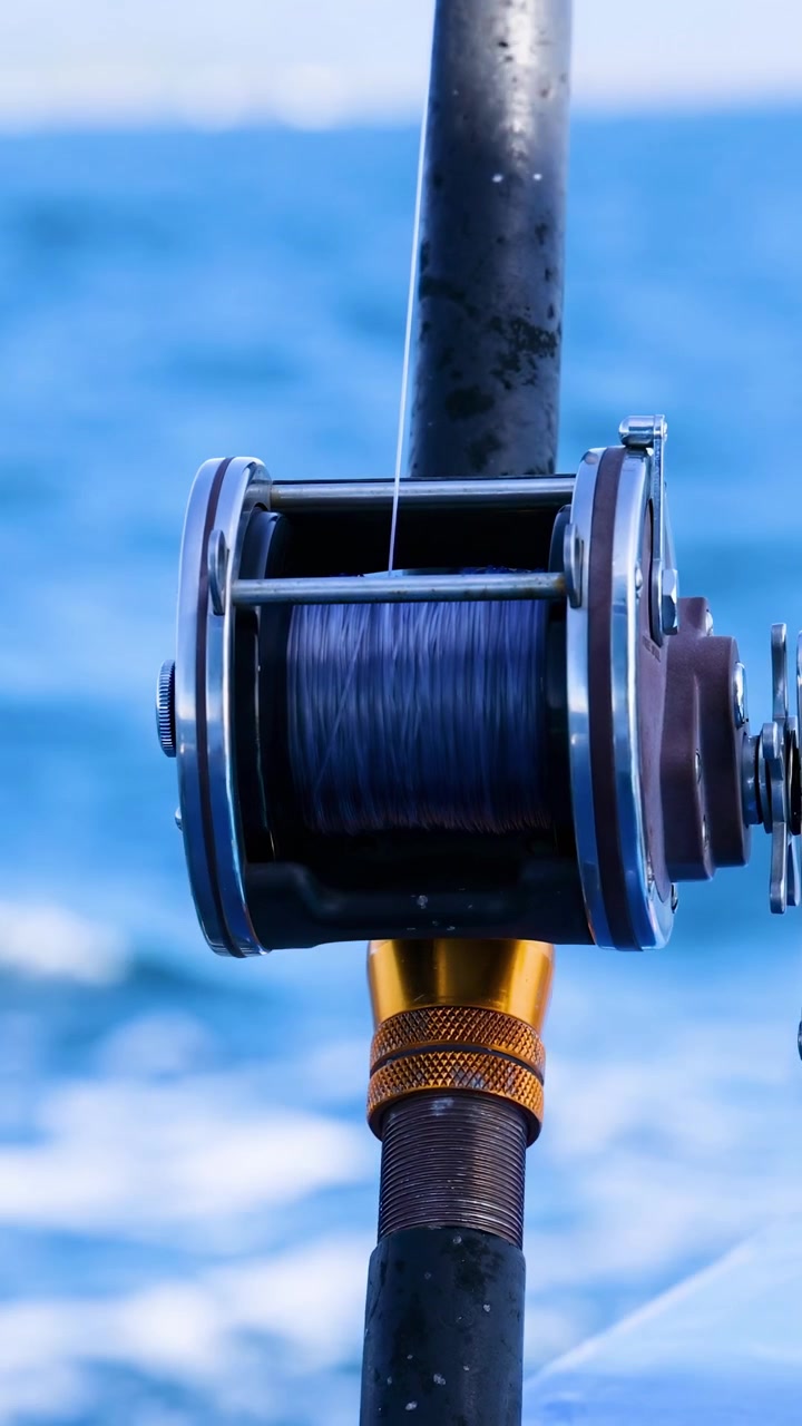 Primo piano di una canna da pesca su una barca a Phuket, Thailandia. La luce solare intensa, il mare calmo e una telecamera stabile catturano la serena ambientazione oceanica.