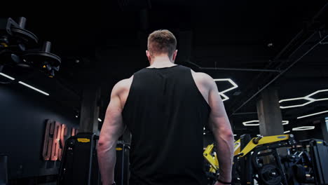 strong bodybuilder with six pack, perfect abs, triceps, chest, shoulders in gym