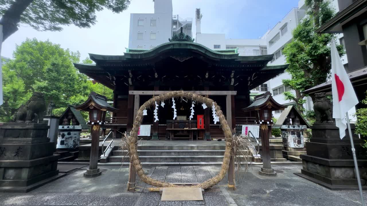 santuario japonés tradicional con una puerta de círculo de paja bajo un cielo azul brillante