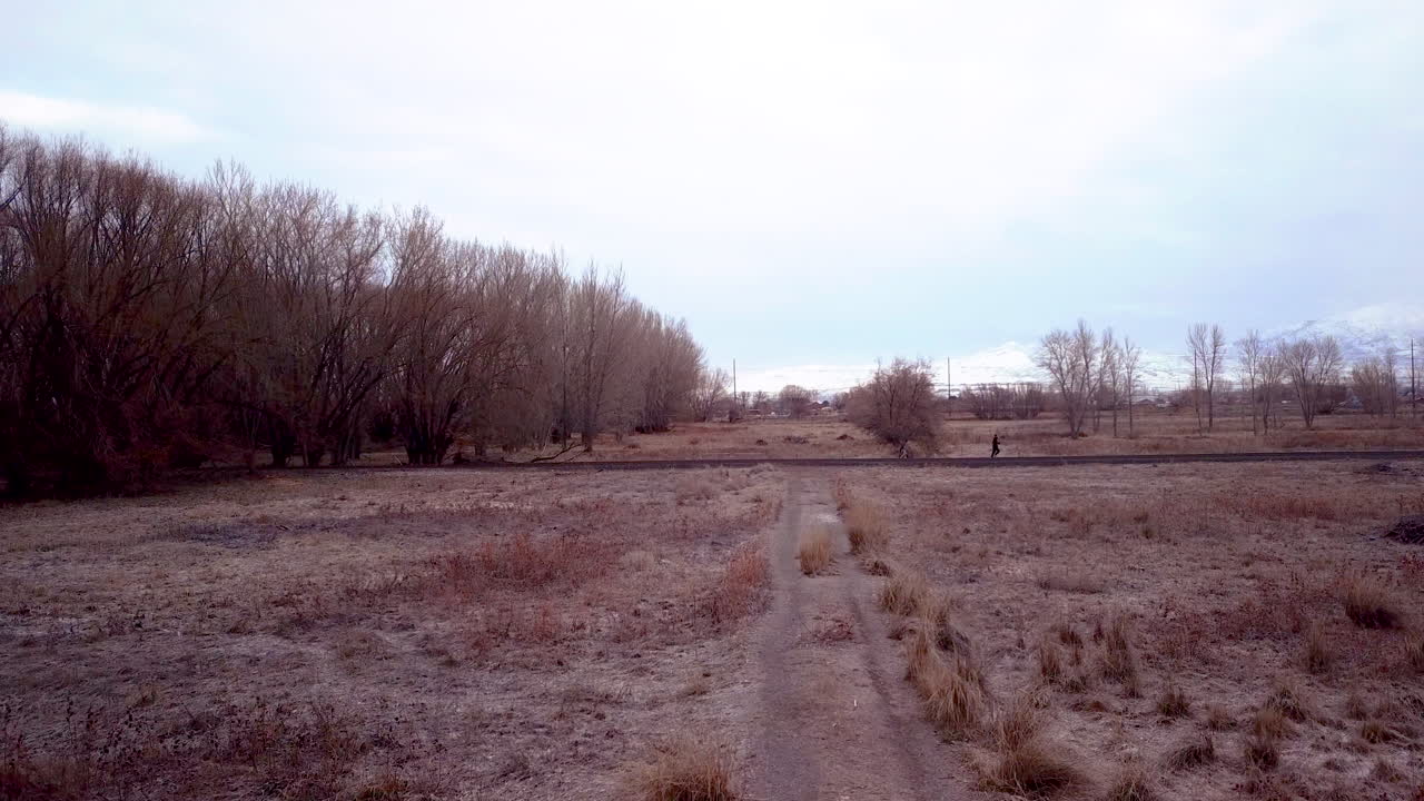 한 남자가 모자와 배낭을 메고 걸어가는 외로운 길의 전망