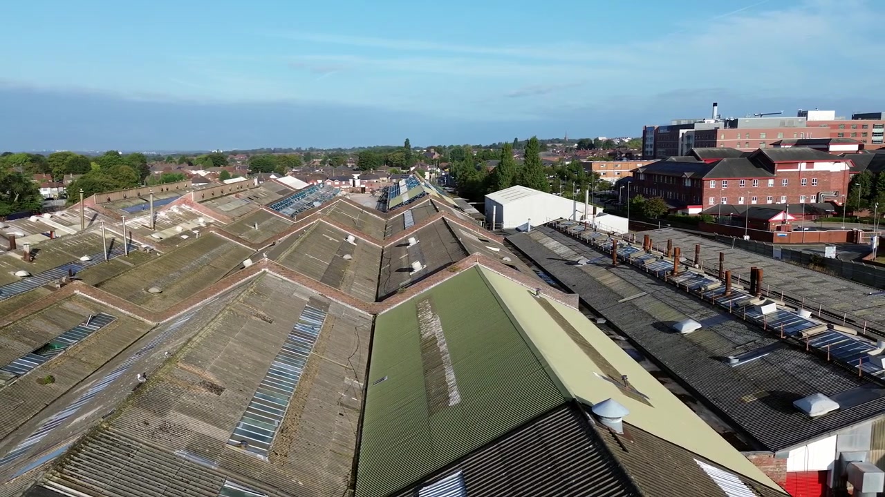 Glen Dimplex industrial factory aerial orbiting view across workshop rooftops and Whiston hospital