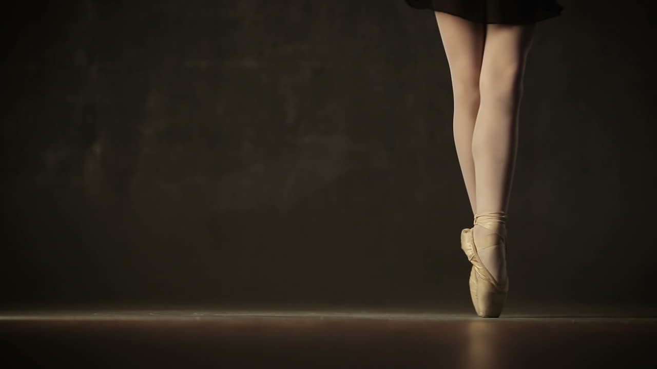 Young ballerina standing on poite in ballet studio
