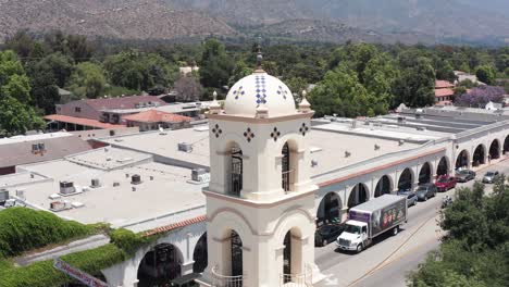 aerial parallax panning shot of the around the belltower of the old post office in downtown ojai, california