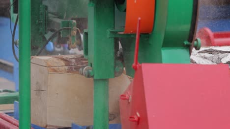 work of the sawmill in close-up. process of machining logs in equipment sawmill machine saw saws the tree trunk on the plank boards.