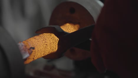 removing hot steel from a lathe during metal forging with tongs