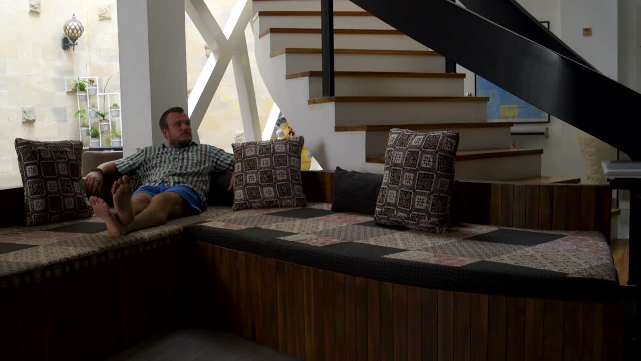 un hombre se acuesta en el sofá en casa