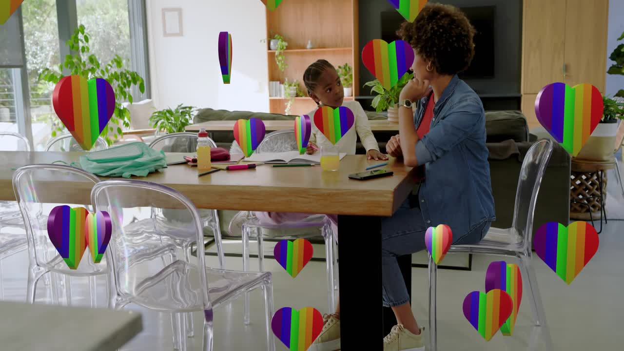 Madre che applaude e crea cuori arcobaleno sopra la scena mentre guida il bambino a scrivere un libro per imparare
