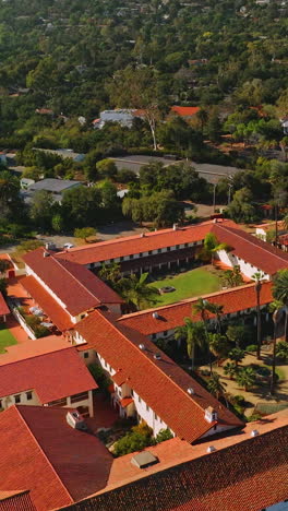 rich luxurious mansions with beautiful buildings and nature around. sunny picture of amazing santa barbara from aerial view. vertical video