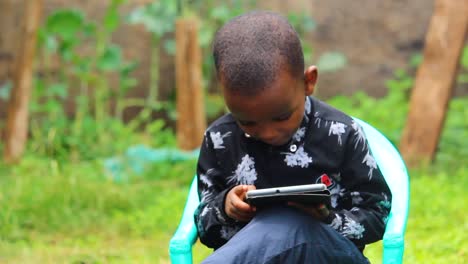 Close-up-of-a-young-African-boy-playing-on-a-tablet-computer,-child,-kid,boy,-African,-ipad,device,-tablet