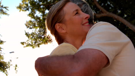 Senior-couple-hugging-on-sunny-day