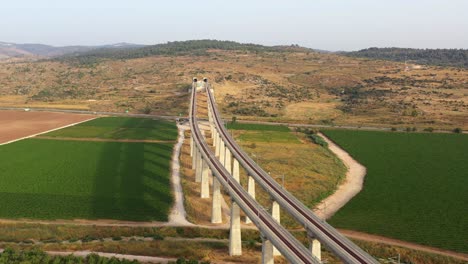 high-angle view of a train viaduct crossing a rural landscape