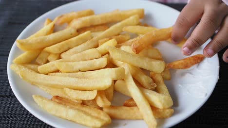 niño comiendo papas fritas