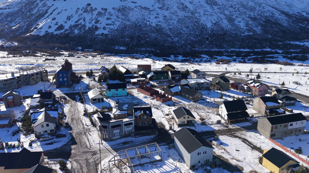 Revealing the snow-covered village of Caviahue, a ski resort nestled at the base of the Andes mountains in Neuquén, Argentina - Aerial trucking shot moves left