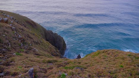 View-Of-Rippling-Blue-Sea-From-The-Lush-Cliff-In-Crescent-Head---New-South-Wales,-Australia---high-angle-slowmo-shot