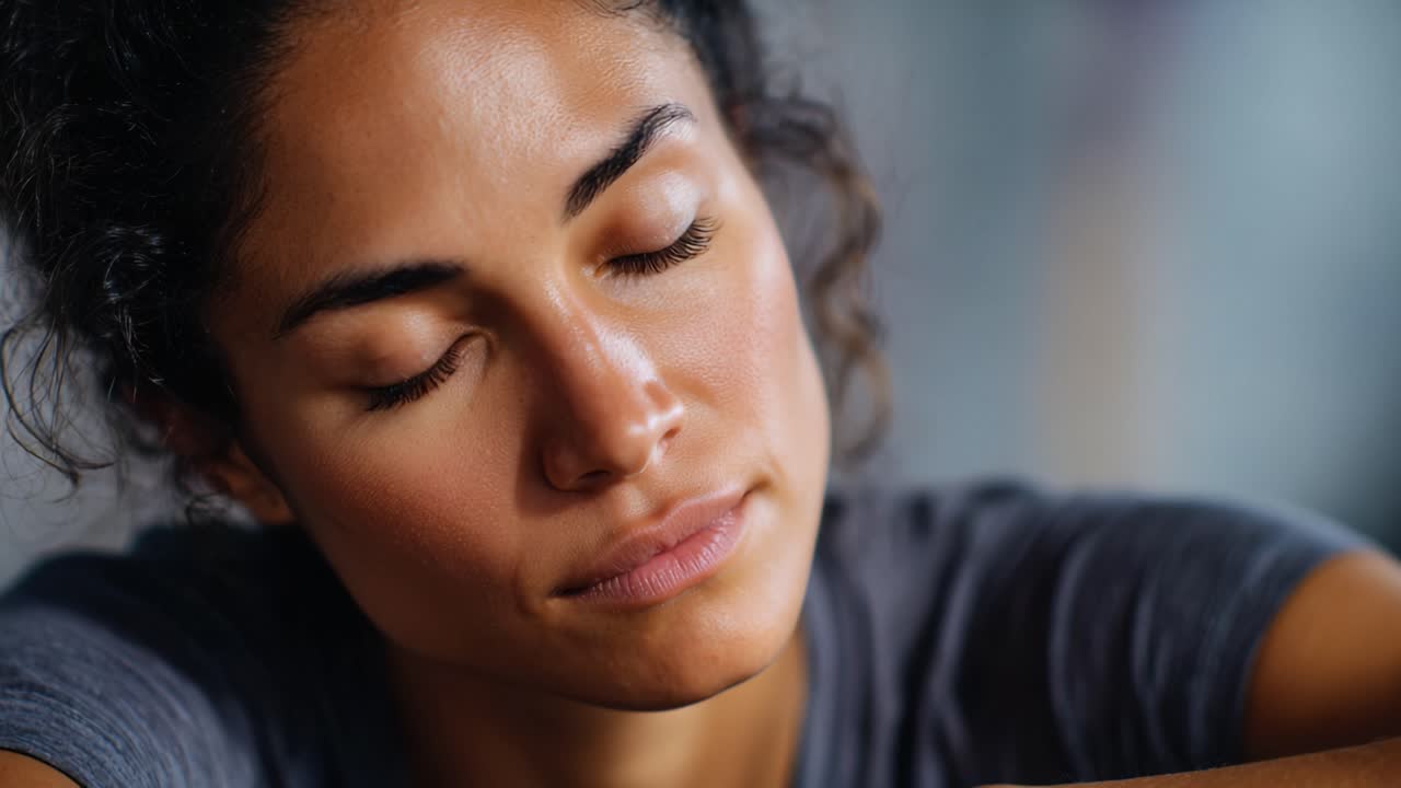 A Thoughtful Moment: A Close-Up of a Woman in Contemplation with Her Eyes Closed, Exuding Serenity and Calmness in a Relaxed Environment