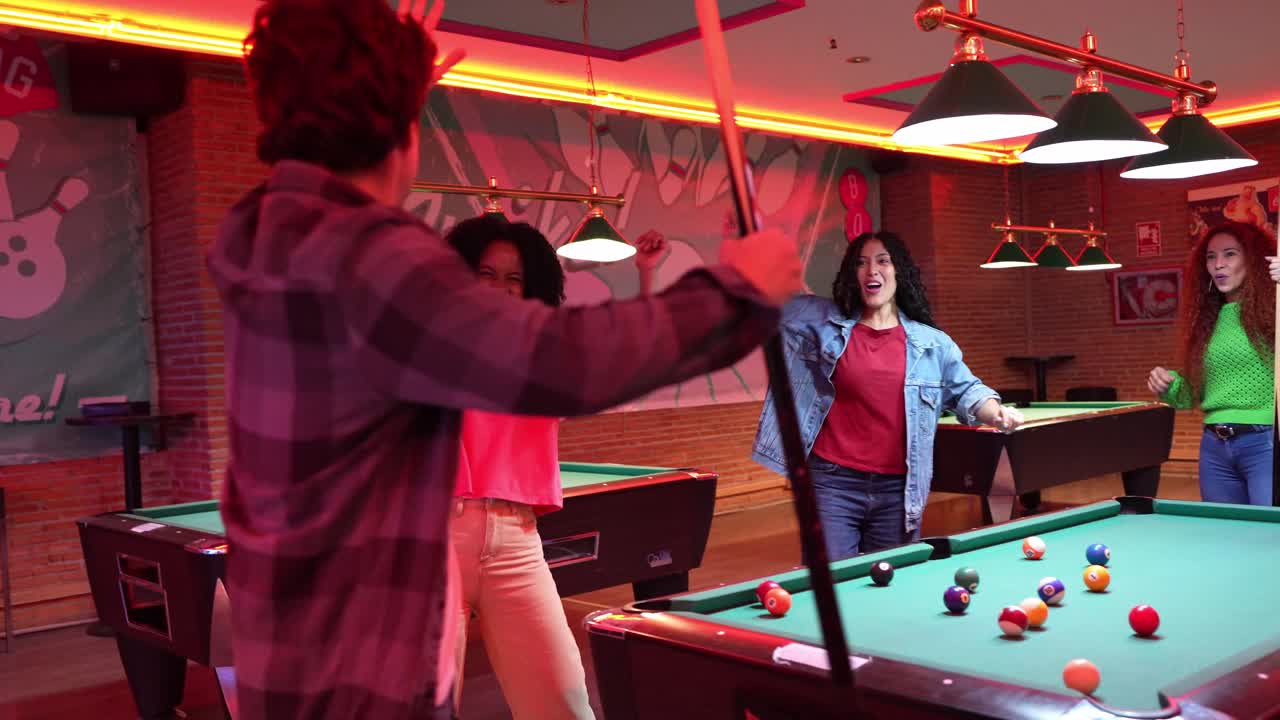 Amigos comemorando em uma mesa de bilhar em uma pista de boliche