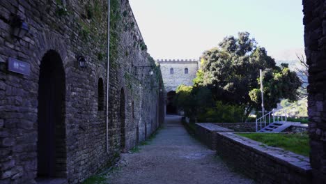 Dentro-De-Altos-Muros-De-Piedra-Del-Castillo-Medieval-De-Gjirokastra,-Caminando-Por-Callejones-Tranquilos-Por-La-Mañana