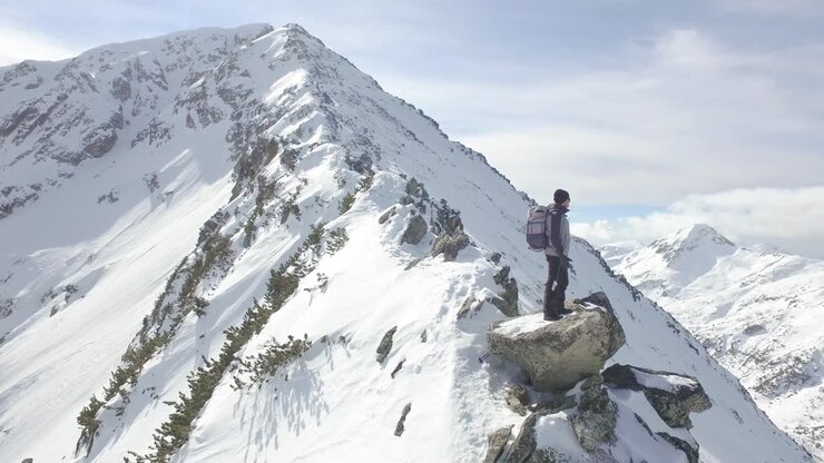 Hiker on Snowy Mountain Summit