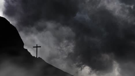 cross silhouette on cliff hills, dark clouds background