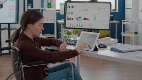 empresario inválido que usa pc y tableta al mismo tiempo comprobando gráficos