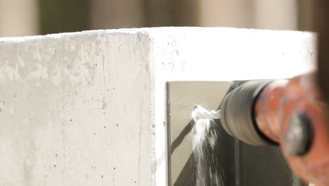 close up of a drill bit drilling hole on concrete wall