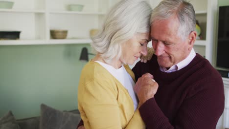 Happy-senior-caucasian-couple-embracing-and-slow-dancing-togther