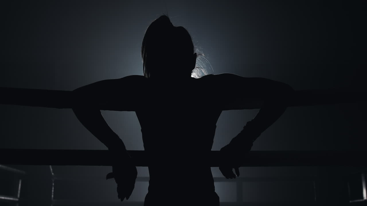 Dramatic Silhouette of a Female Fighter in a Boxing Ring